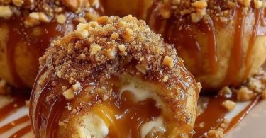Gooey apple caramel bombs drizzled with caramel sauce and topped with chopped nuts