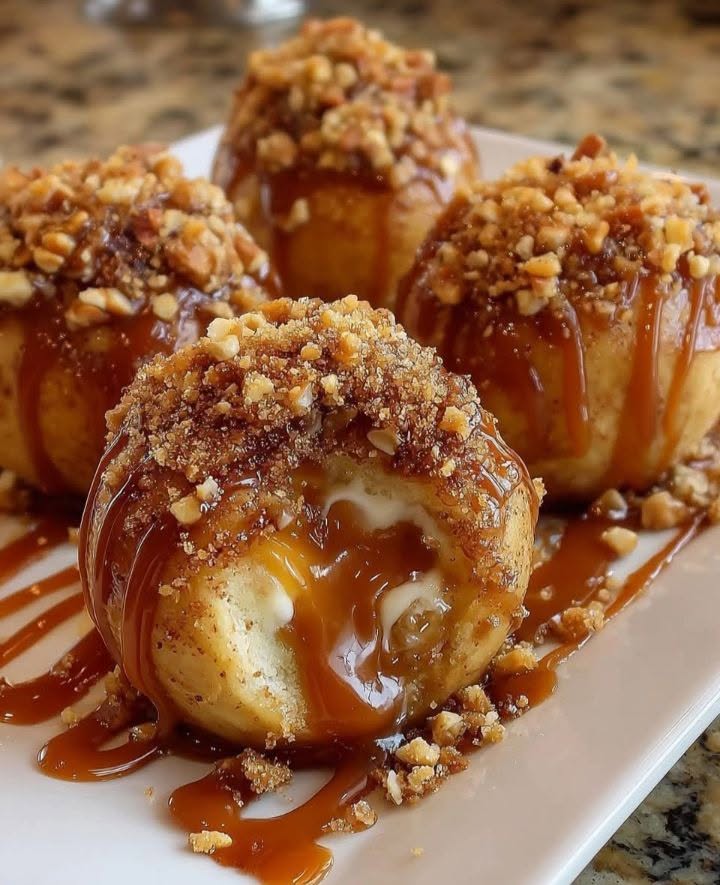 Gooey apple caramel bombs drizzled with caramel sauce and topped with chopped nuts