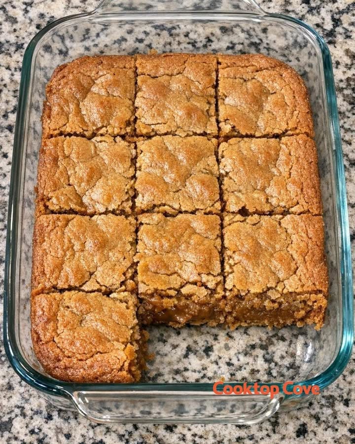 Golden pineapple coconut bars with a crackly top, cut in a glass baking dish