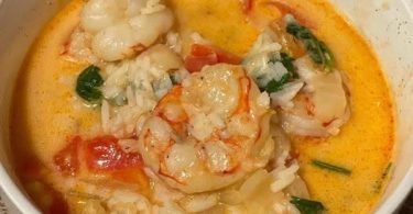 Creamy Thai shrimp soup (Tom Yum style) with shrimp, coconut-red curry broth, rice, and fresh cilantro