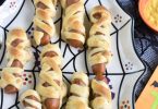 Hot Dog Mummies wrapped in crescent dough on a Halloween plate